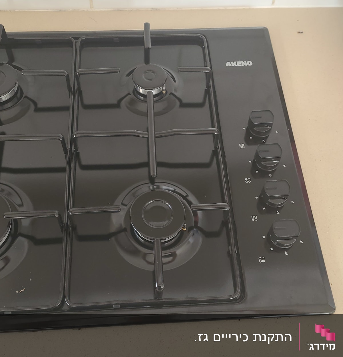 כיריים גז שחורות עם ארבעה מבערים וכפתורי שליטה